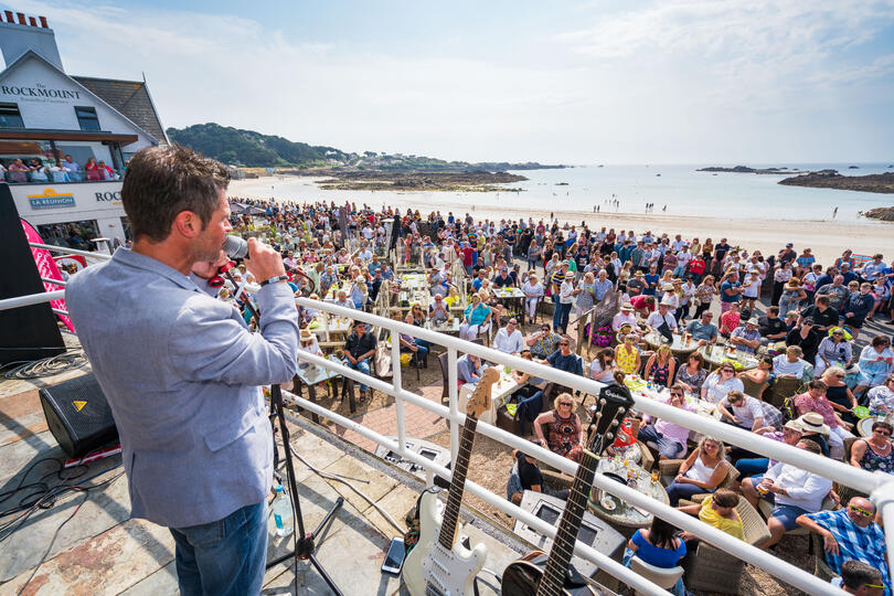 Carl Ward hosting and entertaining the crowds live on stage for a Cobo Balcony Gig event in Guernsey.