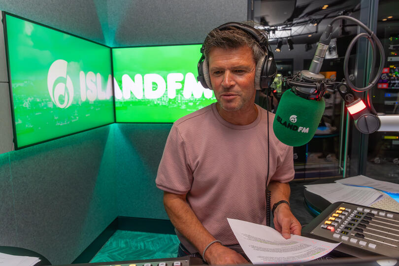 Radio presenter Carl Ward hosting the live mid-morning show on-air at Island FM in Guernsey.